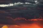Sunset turns cumulus clouds bright red and orange. Art Print